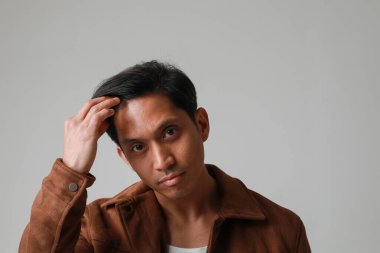 Beyaz arka planda poz verip kameraya bakan Asyalı adamın portresi. Yüksek kalite fotoğraf