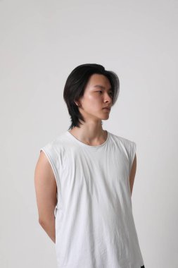 Beyaz arka plan üzerinde günlük kıyafetler giyen şık, yakışıklı Asyalı adamın vesikalığı. Model-up. Yüksek kalite fotoğraf.