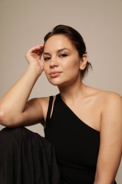 Beyaz duvarda poz veren gülümseyen genç bir kadının portresi. İzole edilmiş. Yüksek kalite fotoğraf.