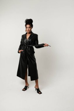 Beyaz arka planda kalan uzun siyah örgülü güçlü Afrikalı Amerikalı genç kadın. Yüksek kalite fotoğraf.