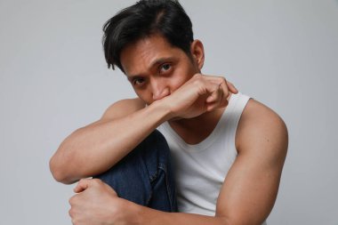 Beyaz arka planda poz verip kameraya bakan yakışıklı Asyalı adamın portresi. Yüksek kalite fotoğraf.