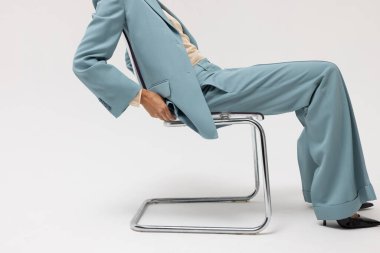 Beyaz duvarın üzerinde poz veren mavi takım elbiseli beyaz bir kadının kesilmiş portresi. Model-up. Yüksek kalite fotoğraf.