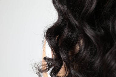 Lüks kıvırcık uzun saçlı, güzel bir genç kadının kesilmiş portresi. Dikey. Yüksek kalite fotoğraf.