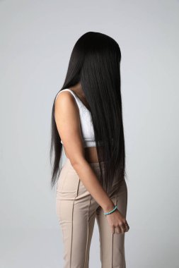 Muhteşem genç bayan, lüks düz saçlarını içeride poz vererek hareket ettiriyor. Yüksek kalite fotoğraf.