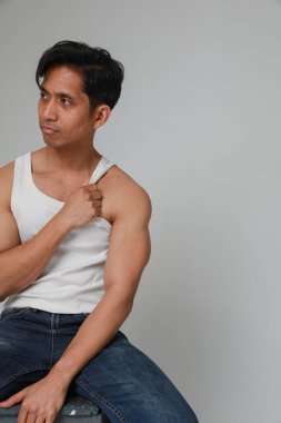 Beyaz arka plan üzerinde poz veren yakışıklı Asyalı adamın portresi başka yöne bakıyor. Dikey. Yüksek kalite fotoğraf.