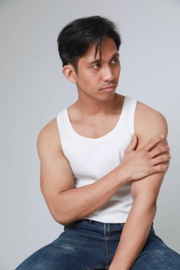 Beyaz arka plan üzerinde poz veren yakışıklı Asyalı adamın portresi başka yöne bakıyor. Dikey. Yüksek kalite fotoğraf.