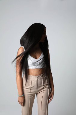 Muhteşem genç bayan, lüks düz saçlarını içeride poz vererek hareket ettiriyor. Yüksek kalite fotoğraf.