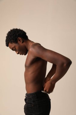 Kameraya bakıp arka planda poz veren Afro-Amerikan genç bir adamın portresi. Dikey maket. Yüksek kalite fotoğraf.