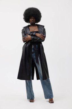 Afro saçlı, iç mekanda poz veren Afro-Amerikan kadının stüdyo portresi. Dikey. Yüksek kalite fotoğraf.