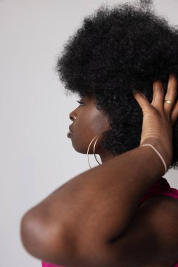 Afro saçlı, iç mekanda poz veren Afro-Amerikan kadının stüdyo portresi. Yüksek kalite fotoğraf.