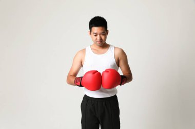 Genç Asyalı boksör kırmızı eldiven giyip beyaz arka planda poz veriyor. Yatay maketler. Yüksek kalite fotoğraf.