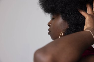 Afro saçlı, iç mekanda poz veren Afro-Amerikan kadının stüdyo portresi. Yüksek kalite fotoğraf.