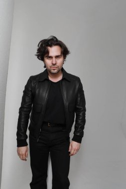 Siyah ceket giyen ve kameraya bakan sakallı yakışıklı adamın portresi. Dikey. Yüksek kalite fotoğraf