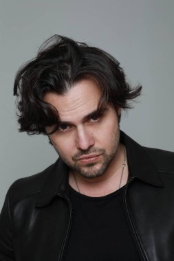 Siyah ceket giyen ve kameraya bakan sakallı yakışıklı adamın portresi. Dikey. Yüksek kalite fotoğraf