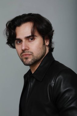 Siyah ceket giyen ve kameraya bakan sakallı yakışıklı adamın portresi. Dikey. Yüksek kalite fotoğraf