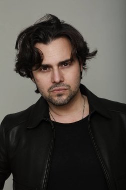 Siyah ceket giyen ve kameraya bakan sakallı yakışıklı adamın portresi. Dikey. Yüksek kalite fotoğraf