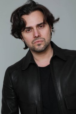 Siyah ceket giyen ve kameraya bakan sakallı yakışıklı adamın portresi. Dikey. Yüksek kalite fotoğraf