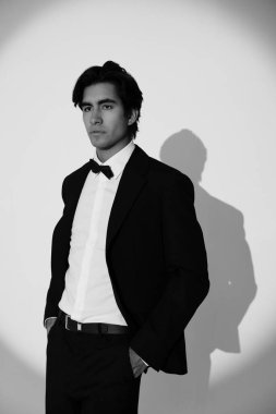 Beyaz arka planda poz veren zarif siyah takım elbiseli yakışıklı genç adamın vesikalığı. İzole edilmiş. Yüksek kalite fotoğraf.