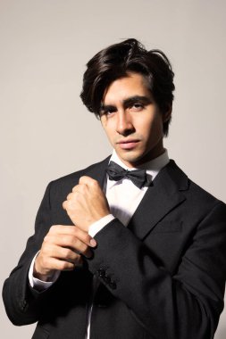 Beyaz arka planda poz veren zarif siyah takım elbiseli yakışıklı genç adamın vesikalığı. İzole edilmiş. Yüksek kalite fotoğraf.