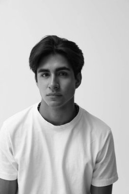 Beyaz arka planda poz veren yakışıklı genç adamın siyah beyaz vesikalığı. Yüksek kalite fotoğraf