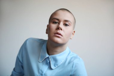 Beyaz arka planda poz veren kendinden emin kel bir kadın. Model-up. Yüksek kalite fotoğraf.