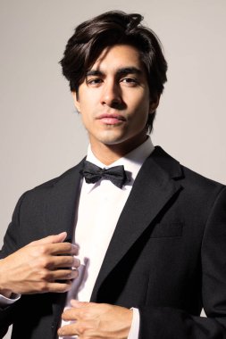 Beyaz arka planda poz veren zarif siyah takım elbiseli yakışıklı genç adamın vesikalığı. İzole edilmiş. Yüksek kalite fotoğraf.