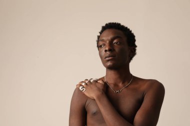 Hafif arka planda poz veren Afrikalı Amerikalı genç bir adamın portresi. Model-up. Yüksek kalite fotoğraf.