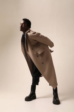Genç Afro-Amerikan bir adamın portresi açık arkaplanda poz veren kışlık bir ceket giyiyor. - Evet. Yüksek kalite fotoğraf.