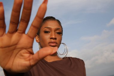 Sahilde poz veren kısa saçlı Afro-Amerikan bir kadının açık hava portresi. - Evet. Yüksek kalite fotoğraf.