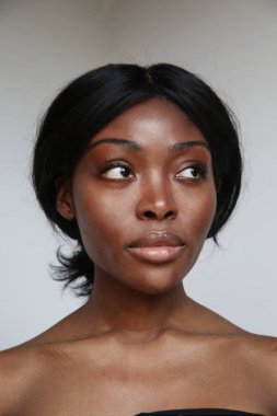 Kusursuz cildini ve güzel makyajını sergileyen doğal güzelliği olan genç bir Afro-Amerikan kadının dikey portresi. Yüksek kalite fotoğraf.