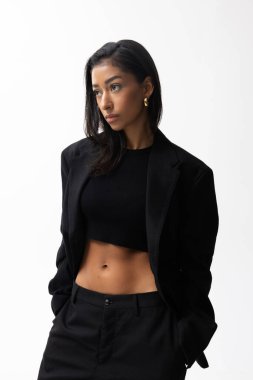 Genç ve güzel bir kadın beyaz arka planda siyah ceket giyiyor. Dikey. Yüksek kalite fotoğraf.