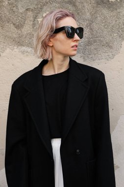 Pembe saçlı, güneş gözlüğü takan genç bir kadının dikey portresi. Yüksek kalite fotoğraf.