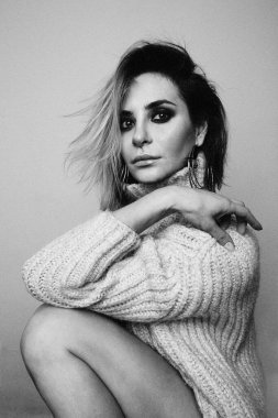 Çekici sarışın bir kadının dikey siyah beyaz portresi. Kapalı alanda poz vermek. Yüksek kalite fotoğraf.