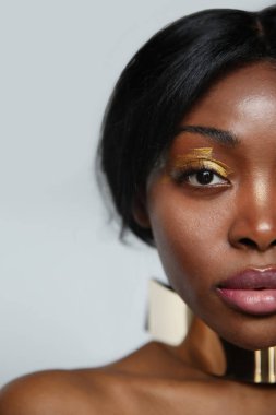 Kusursuz derisi ve güzel makyajıyla, doğal güzelliği olan genç Afrikalı Amerikalı bir kadının vesikalık fotoğrafı. Yüksek kalite fotoğraf.