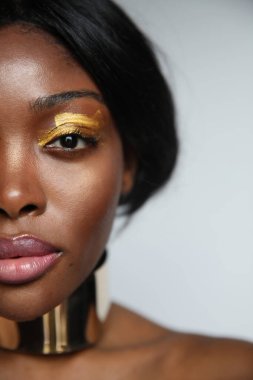 Kusursuz cildini ve güzel makyajını sergileyen doğal güzelliği olan Afro-Amerikan bir kadının çarpıcı portresi. Yüksek kalite fotoğraf.