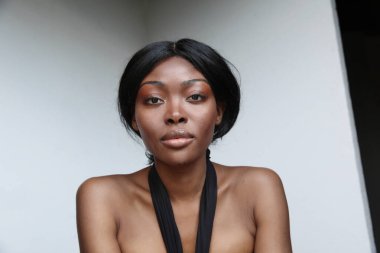 Kusursuz cildini ve güzel makyajını sergileyen doğal güzelliği olan Afro-Amerikan bir kadının çarpıcı portresi. Yüksek kalite fotoğraf.