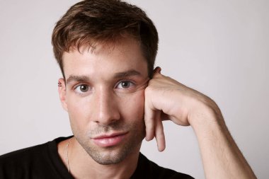 Ciddi yüz ifadesi olan genç yakışıklı bir adam kameraya bakıyor. Akıl sağlığı. Yüksek kalite fotoğraf.