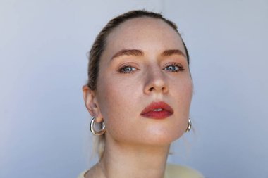 Beyaz arka planda poz veren beyaz bir kadının dikey portresi. Yüksek kalite fotoğraf.