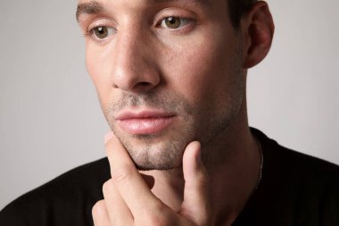 Yüzünde ciddi bir ifade olan yakışıklı bir adamın portresi başka tarafa bakıyor. Beyaz arka plan. Yüksek kalite fotoğraf.