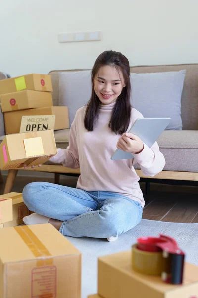 开办小企业的形象 亚洲妇女在网上查看订单 在总部销售与盒装公司自由职业工作有关的产品 传播商业理念 — 图库照片