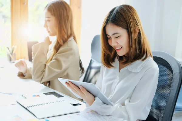 stock image Negotiation, Analysis, Discussion, Portrait of an Asian women economist and marketer using tablet computer to plan investments and financial to prevent risks and losses for the company.