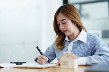 Teminat, ipotek, sözleşme, sözleşme, imza, erkek müvekkil emlakçı veya banka memuruyla arazi kredisi imzalamak için anlaşma belgesine kalem tutuyor