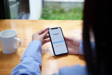 CHIANG MAI, THAILAND - 30 Haziran 2022: Instagram uygulamasının giriş ekranı olan akıllı telefonu tutan kadın. Instagram en büyük ve en popüler sosyal ağdır..