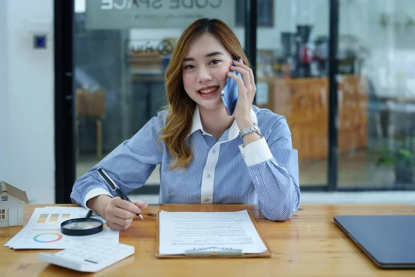 휴대폰 컴퓨터 문서를 책상에 얼굴을 아시아의한 여성의 — 스톡 사진