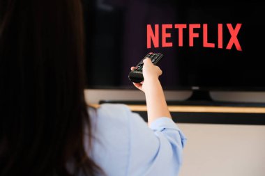 Chiang Mai Tayland, 2020 Haziran 07 - Genç bir kadın evinde ve televizyonunda Netflix izliyor