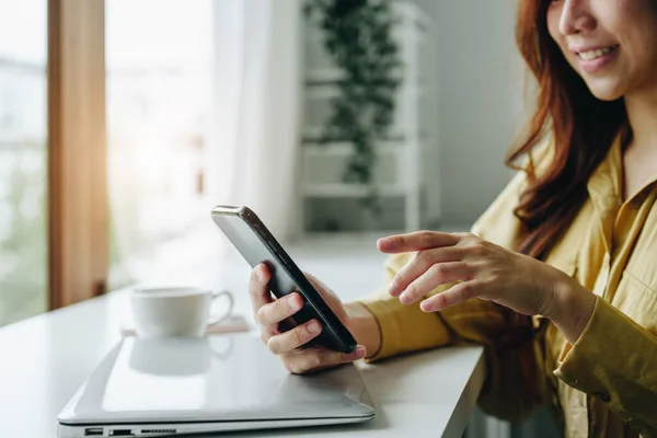 stock image Portrait of a woman using her phone to make video calls or call a friend while taking a break at her desk.