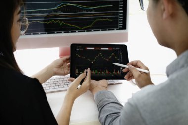 Yatırım uzmanı, borsayı analiz etmek için tablet monitörüne kalem doğrultur ve size nasıl kar edeceğinizi öğretir.