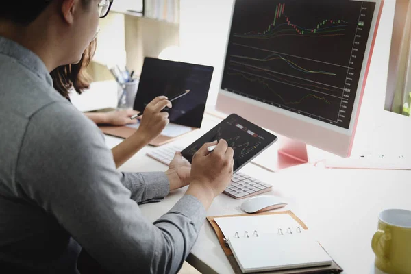 投資の専門家は 利益を上げる方法を教えるために株式市場を分析するためにコンピュータモニタでペンを指す — ストック写真