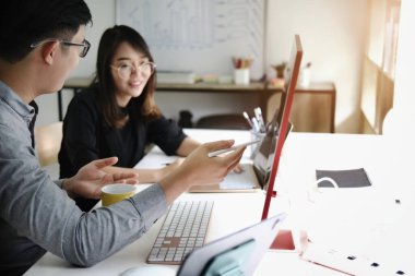 Yatırım uzmanı, borsayı analiz etmek ve size nasıl kar edeceğinizi öğretmek için bilgisayar monitörüne kalem doğrultuyor.