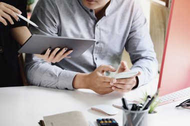 Sekreter şirketin bu çeyrekteki karlılık bütçesi hakkında konuşmak için tablet kullanırken akıllı telefon kullanan adamlara odaklanın.
